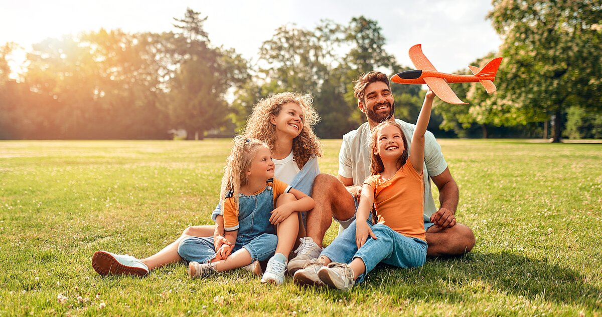 Eine Familie auf einem Rasen sitzend Eine Familie auf einem Rasen sitzend